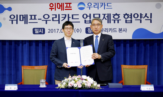 5일 서울 종로구 우리카드 본사에서 열린 '위메프-우리카드 업무제휴 협약식'에서 하송 위메프 부사장(왼쪽)과 이춘국 우리카드 부사장이 기념촬영을 하고 있다. 우리카드 제공